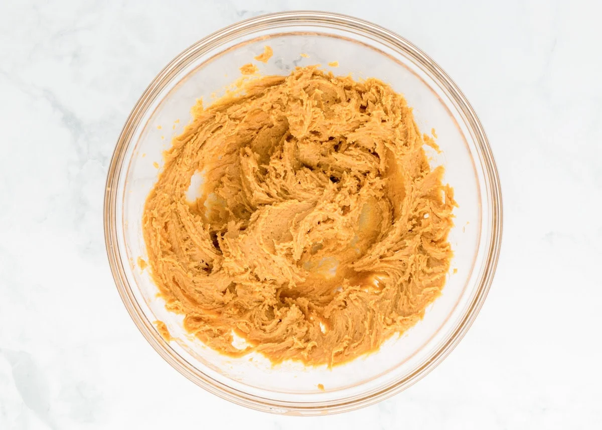 Delicious 3 ingredient peanut butter cookies take just minutes to throw together and are so easy the kids can make them! Peanut butter cookie dough in a mixing bowl.