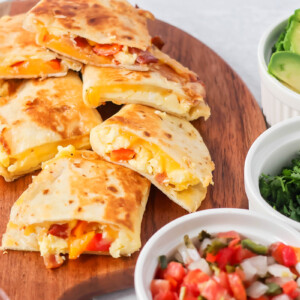 Slices of breakfast quesadilla served on a wood board.
