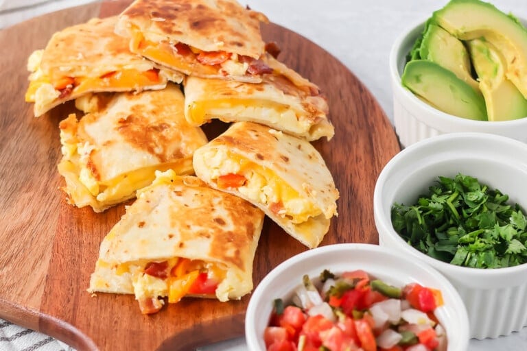 Slices of breakfast quesadilla served on a wood board.
