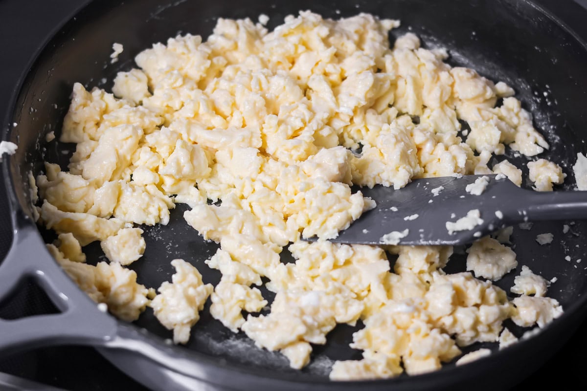 Crispy breakfast quesadillas packed with savory ingredients for a fast family meal that works for breakfast or dinner. Scrambling eggs in a skillet.