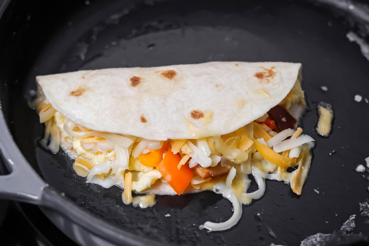 Crispy breakfast quesadillas packed with savory ingredients for a fast family meal that works for breakfast or dinner. Half a torilla folded over the filling.