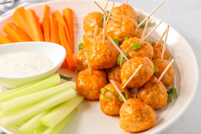 Buffalo chicken meatballs served alongside carrot sticks, ranch, and celery sticks.