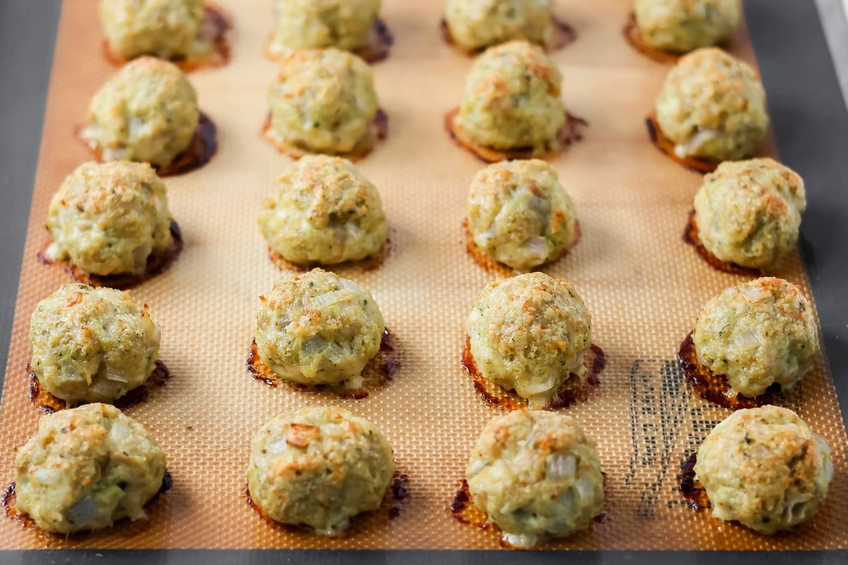 These easy chicken pesto meatballs come together in 30 minutes for a flavorful, family-friendly dinner full of basil and parmesan goodness. Cooked meatballs on a baking sheet.