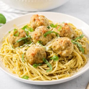 Chicken pesto meatballs served over noodles.
