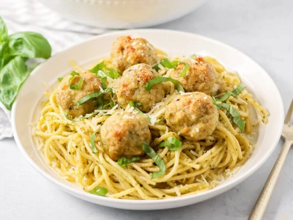 Chicken pesto meatballs served over noodles.