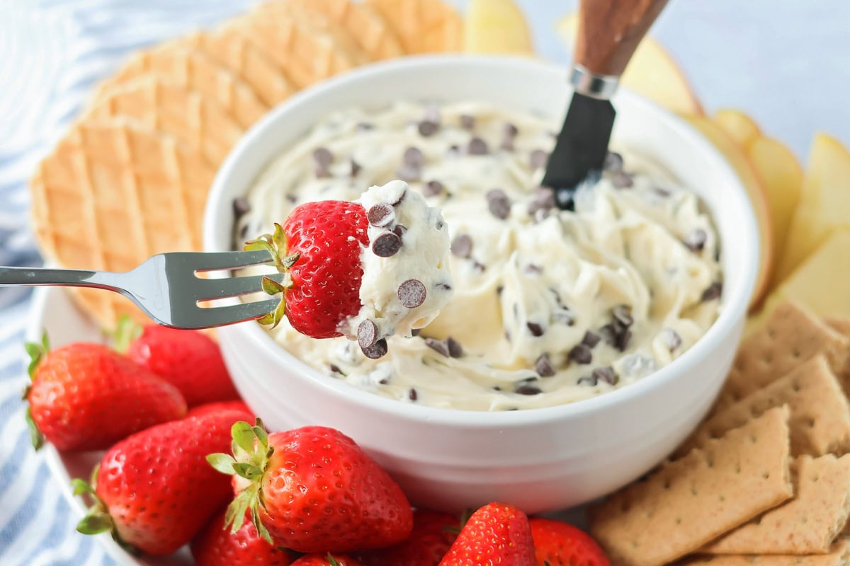 Dipping a strawberry into chocolate chip dip.