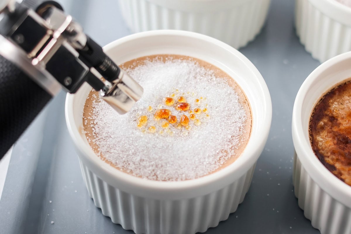 Torching sugar on chocolate creme brûlée recipe.