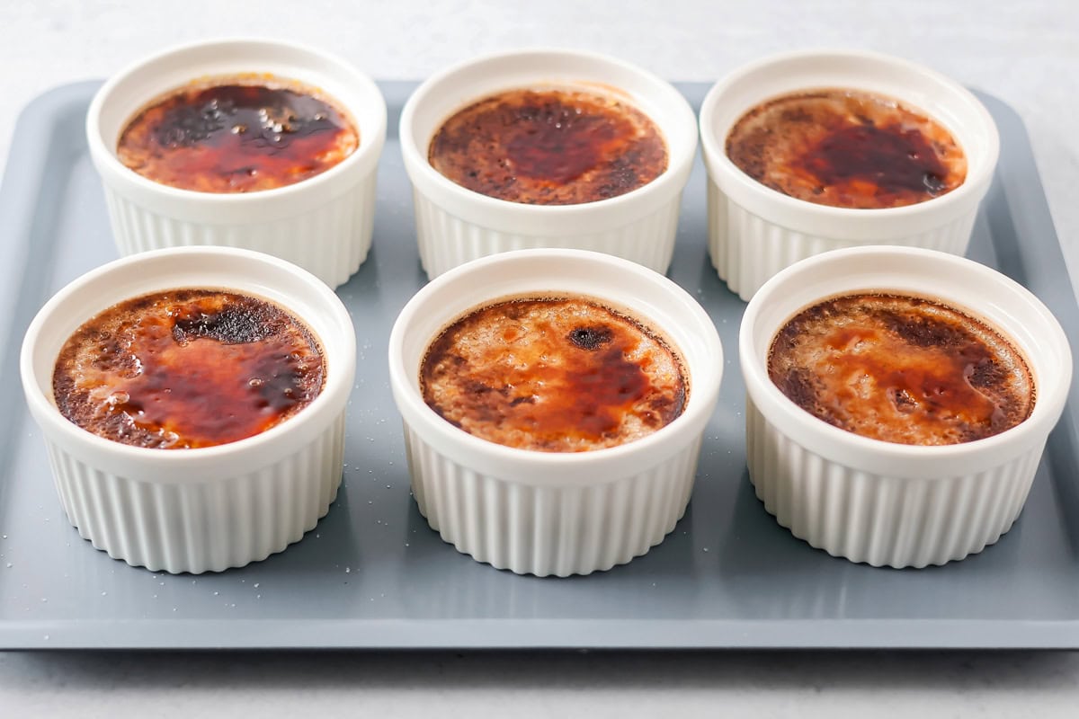 Chocolate creme brûlée in ramekins on dish.