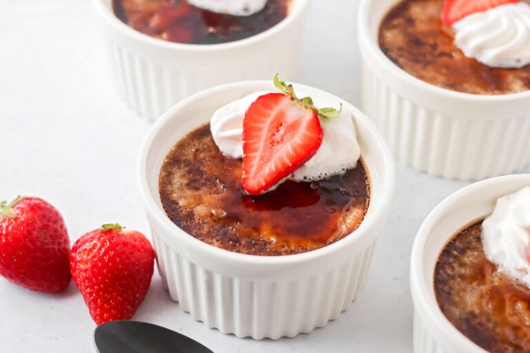Chocolate creme brûlée in ramekins with strawberry on top.