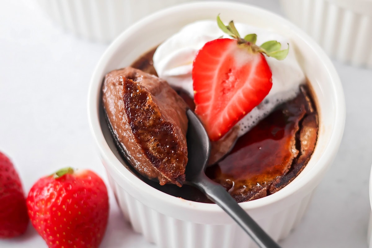 Spooning out some chocolate creme brulee from ramekin.
