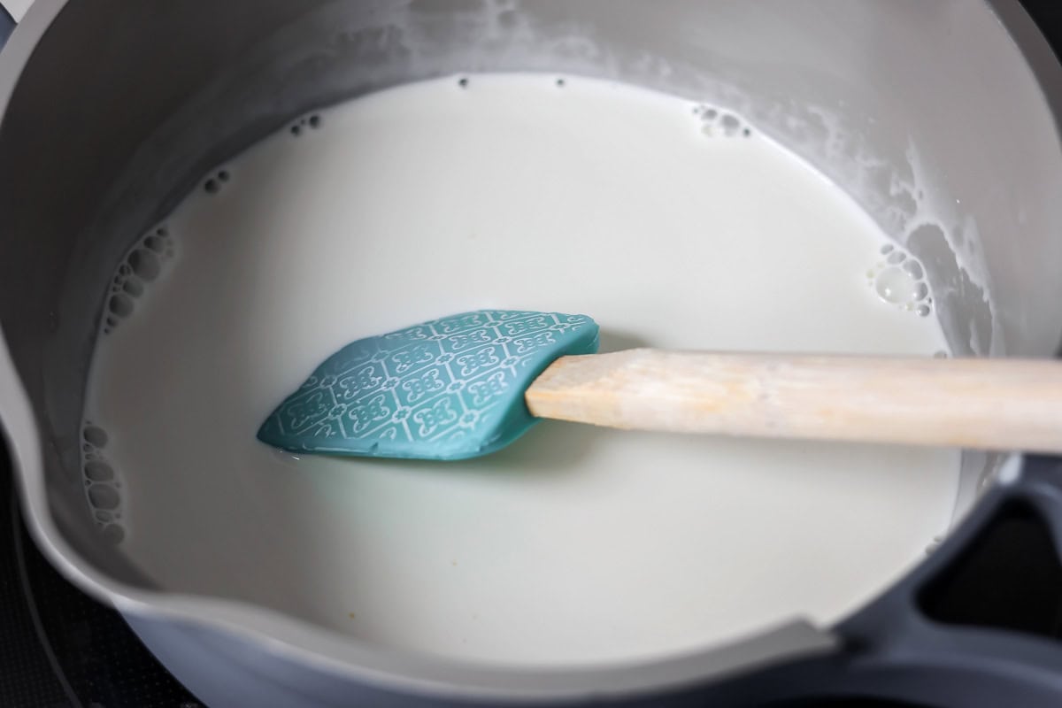 Mixing cream and half and half in pot.