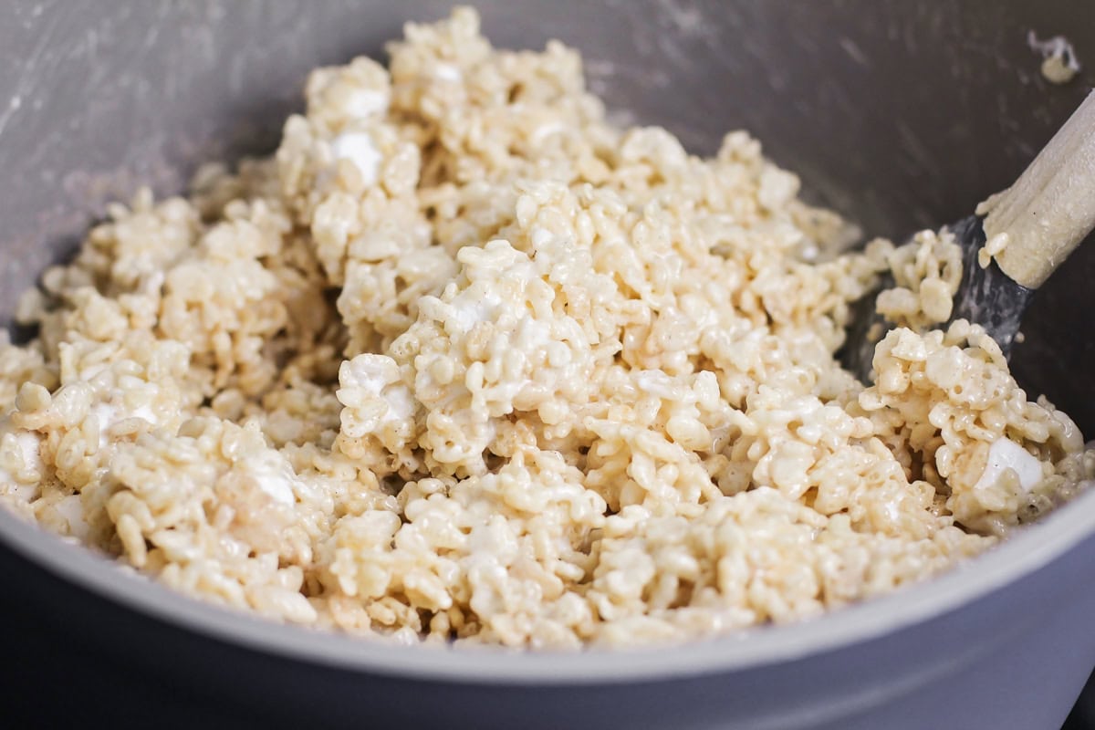 These no bake churro Rice Krispie treats showcase extra marshmallows and a cinnamon sugar topping for sweet, soft, and cozy bites. Mixing cereal and marshmallows into the melted marshallows.