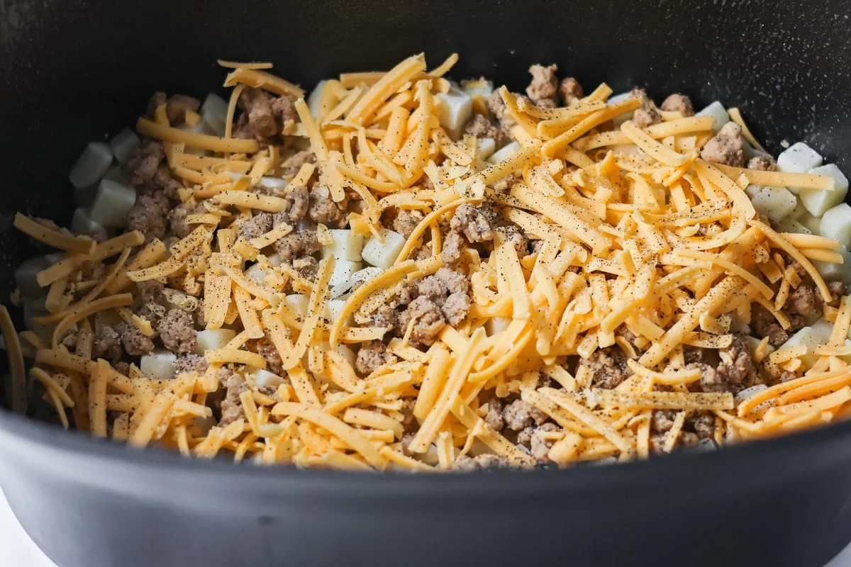 Crockpot breakfast casserole layers favorite breakfast foods for an easy and cozy dish that feeds a crowd with almost no effort. Shredded cheese and sausage crumbles added to a crockpot.