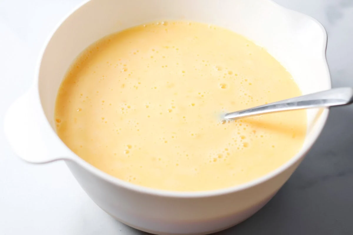 Crockpot breakfast casserole layers favorite breakfast foods for an easy and cozy dish that feeds a crowd with almost no effort. Egg custard in a mixing bowl