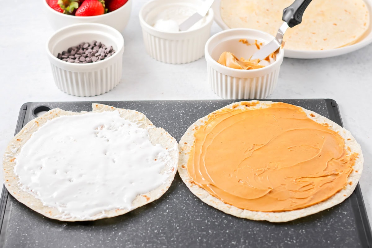 Tortillas with peanut butter and marshmallow cream spread on to them.