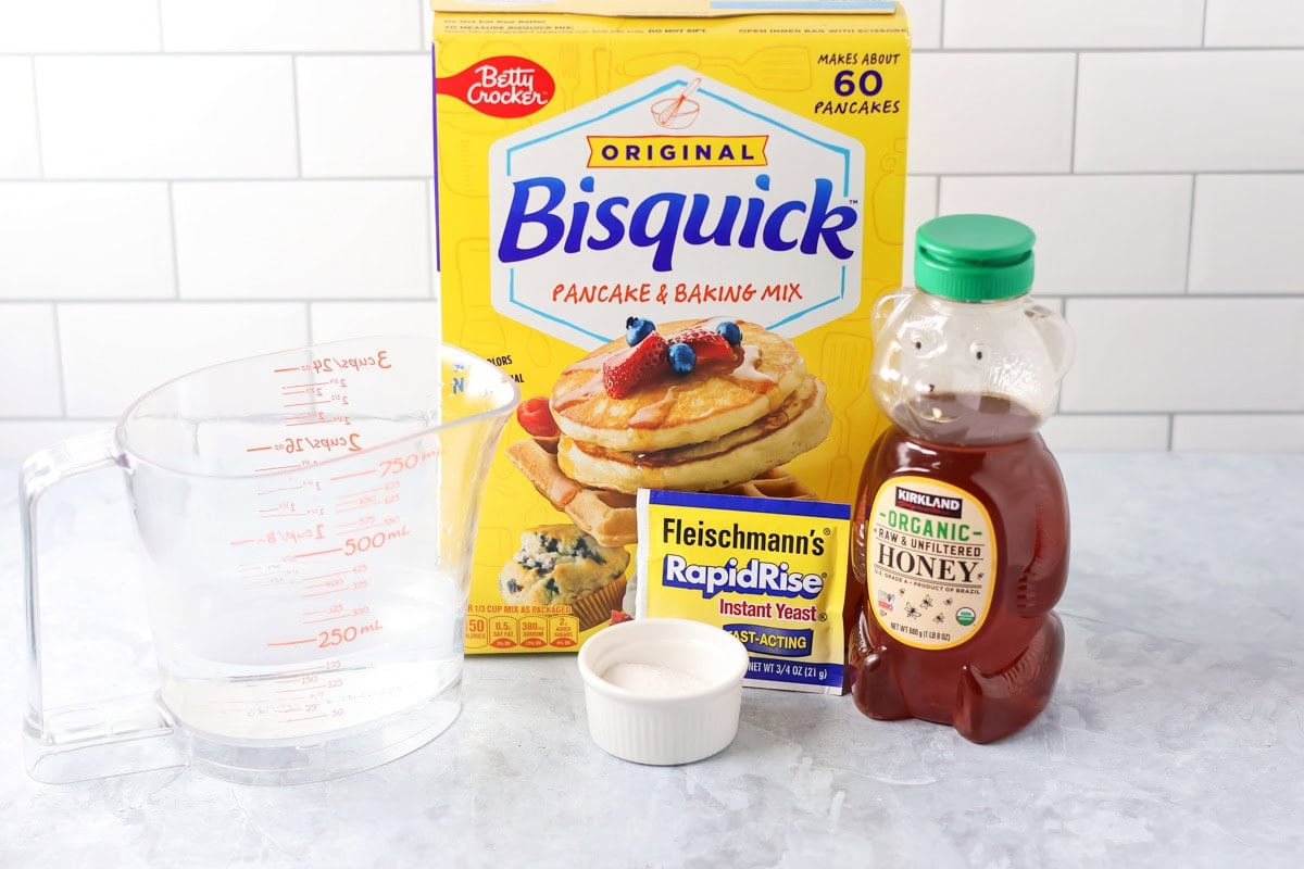 With just 4 ingredients, these easy yeast rolls are ready in under an hour and are perfect for a light snack or served with dinner. Ingredients to make easy yeast rolls on a kitchen counter.