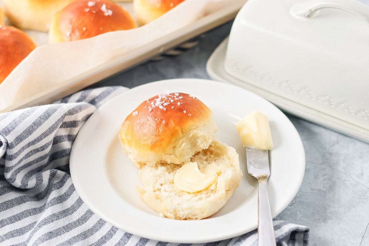 With just 4 ingredients, these easy yeast rolls are ready in under an hour and are perfect for a light snack or served with dinner. A salted roll cut in half with a pat of butter in the center.