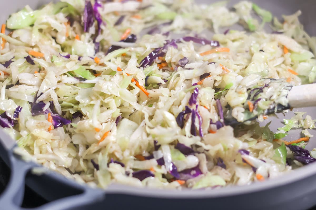 Uncooked egg roll filling in a skillet.