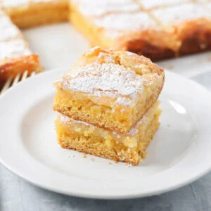 Two slices of gooey butter cake stacked on a white plate.