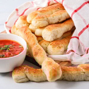 Homemade marinara sauce served alongside breadsticks.