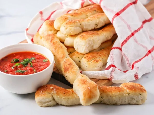 Homemade marinara sauce served alongside breadsticks.