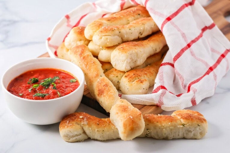 Homemade marinara sauce served alongside breadsticks.