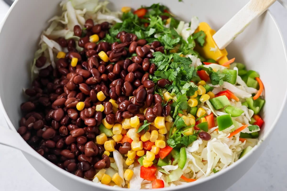 Ingredients for Mexican Coleslaw in white mixing bowl.