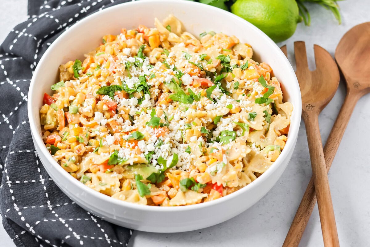 Creamy Mexican street corn pasta salad is a perfect balance of flavor, quick to toss together, and perfect for parties and easy dinners. A serving bowl filled with Mexican street corn pasta salad.