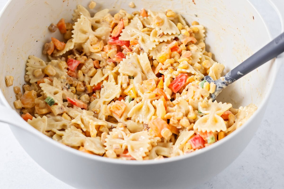 Creamy Mexican street corn pasta salad is a perfect balance of flavor, quick to toss together, and perfect for parties and easy dinners. Mixing pasta and veggies with dressing,