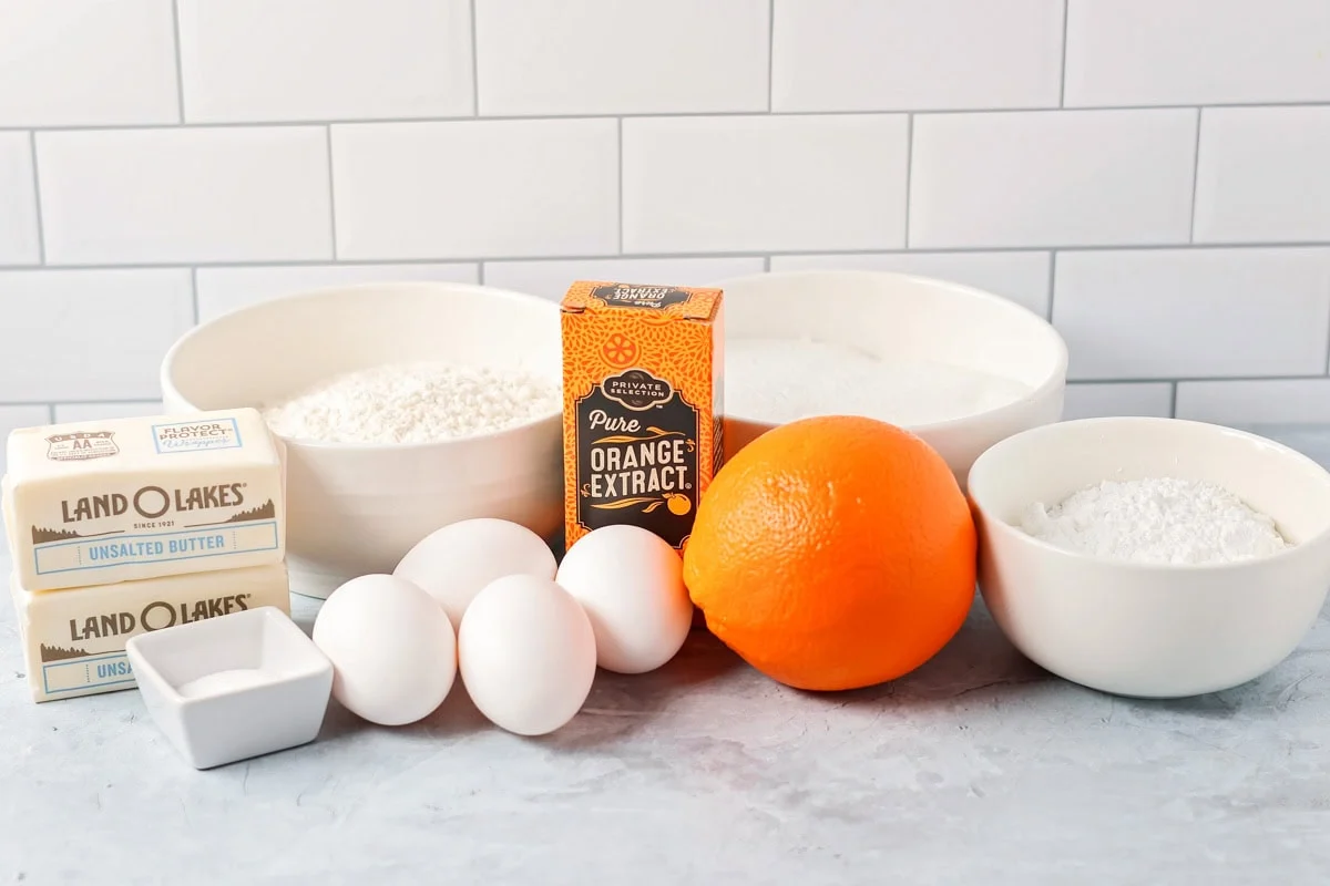 Soft orange brownies are made with simple ingredients, a quick bake, and a bright flavor that makes every slice feel special. Ingredients to make orange brownies on a kitchen counter.