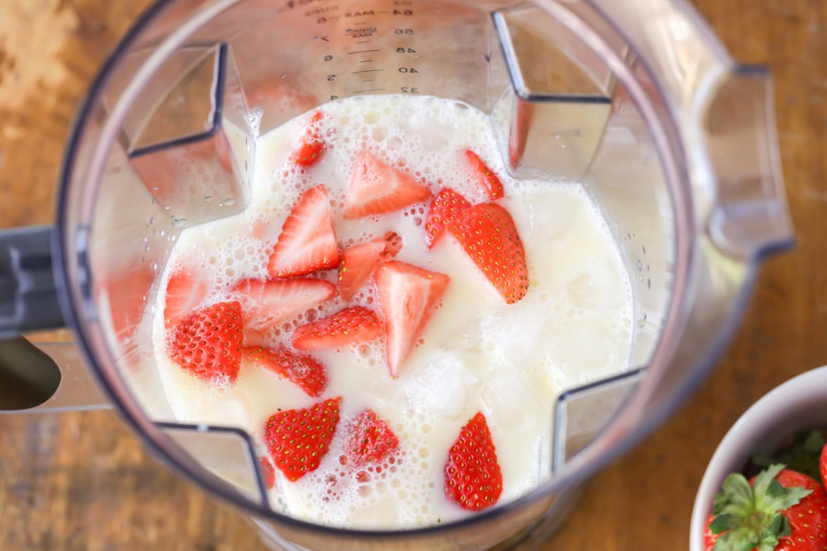 Blend a bright orange juice smoothie in 5 minutes, packed with strawberries, vanilla, and vitamin C for a quick breakfast the kids love. Ingredients for an orange juice smoothie in a blender.