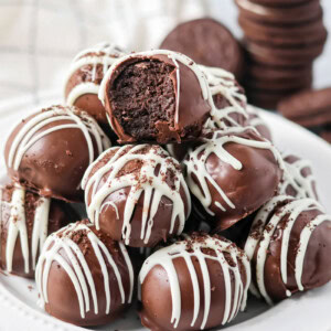 Stack of Oreo cream cheese balls on a white dinner plate.