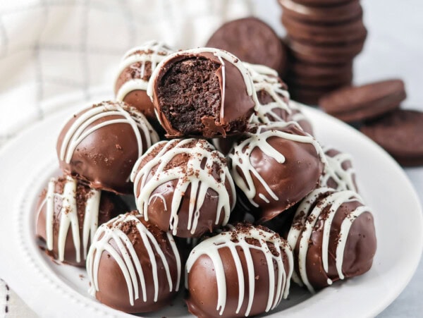 Stack of Oreo cream cheese balls on a white dinner plate.