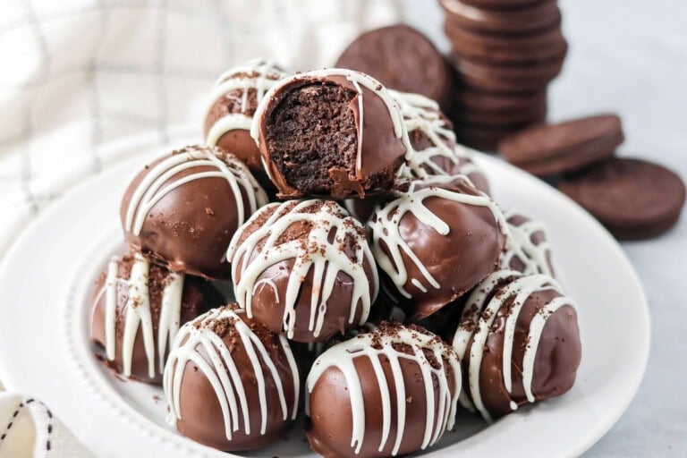 Stack of Oreo cream cheese balls on a white dinner plate.