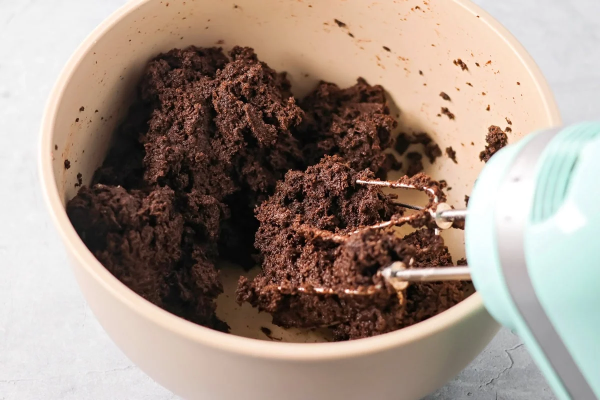 No-bake Oreo cream cheese balls are a three ingredient treat with a silky center and chocolate coating, ideal for every occasion. Chocolate dough in a mixing bowl.