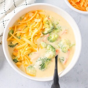 Homemade Panera broccoli cheddar soup served in a bowl and topped with extra cheese.