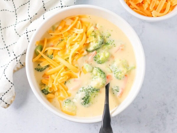 Homemade Panera broccoli cheddar soup served in a bowl and topped with extra cheese.