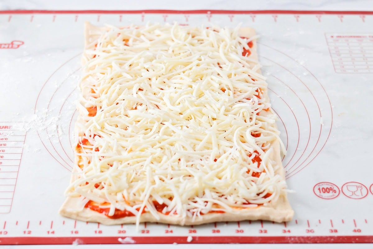 Pizza pinwheels process image - shredded cheese on top.