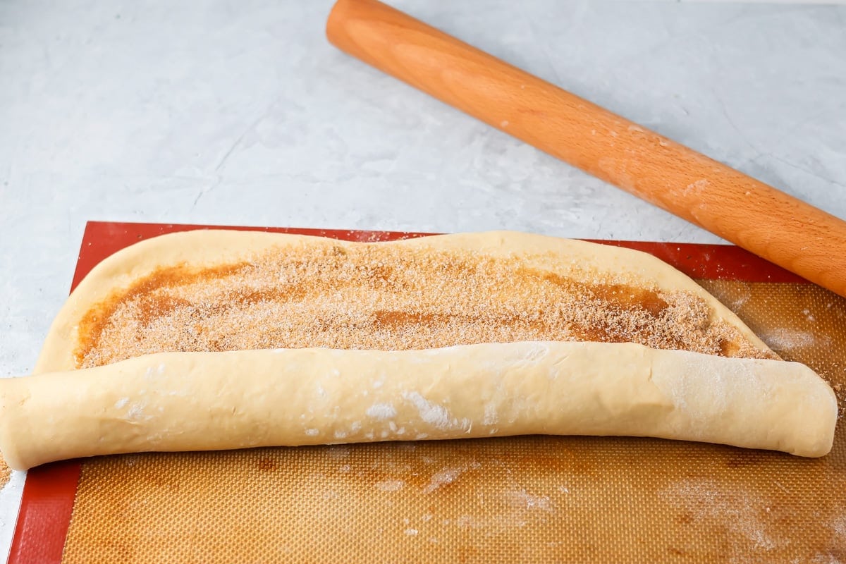 Quick cinnamon twists are made with a simple soft, buttery dough, and swirled with cinnamon sugar and are perfect for breakfast or dessert. Rolling a cinnamon sugared sheet of dough into a log.