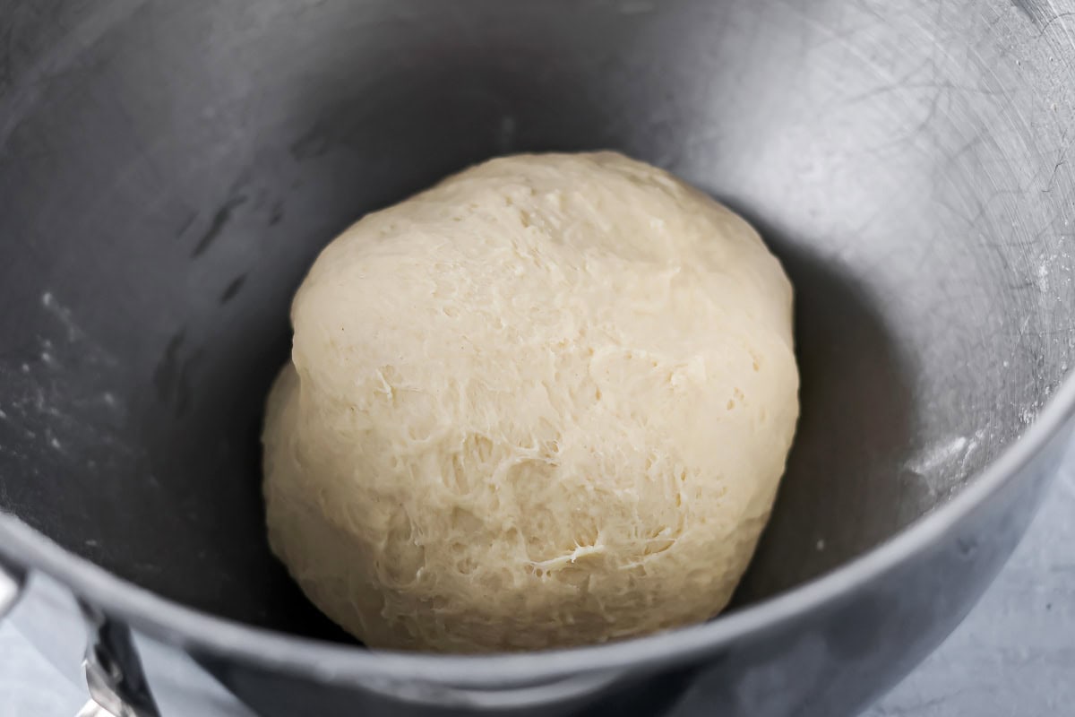 Quick cinnamon twists are made with a simple soft, buttery dough, and swirled with cinnamon sugar and are perfect for breakfast or dessert. A ball of dough in a mixing bowl.