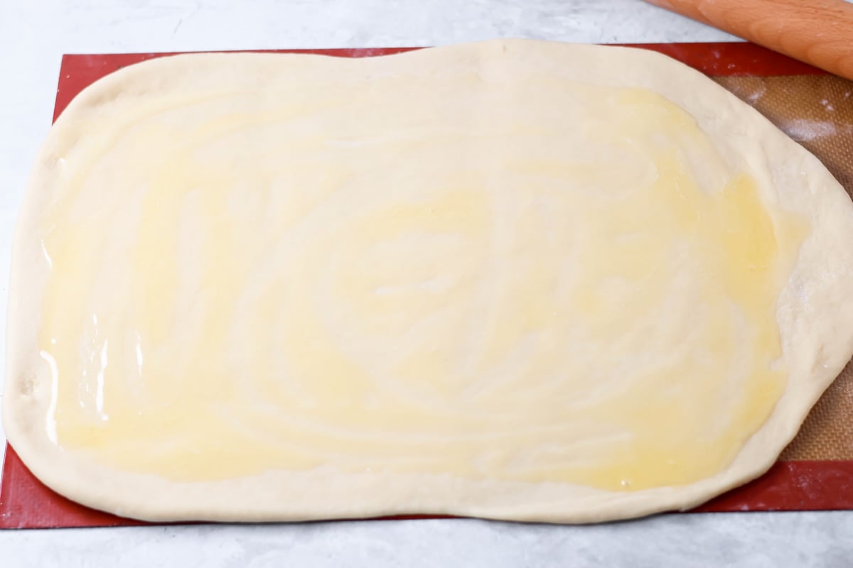 Quick cinnamon twists are made with a simple soft, buttery dough, and swirled with cinnamon sugar and are perfect for breakfast or dessert. Melted butter spread over rolled out dough.