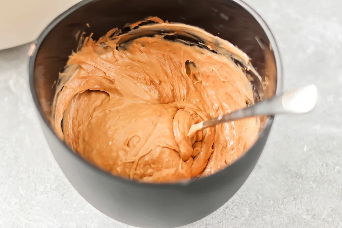 Stirring melted chocolate into the cheesecake filling.