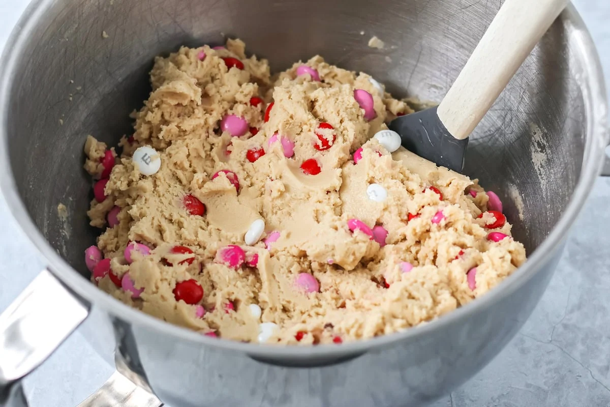 Valentines Day cookies are soft and chewy with chocolate pops of pink, red, and white M&M's. They are Valentine's perfection! Cookie dough with M&M's mixed in.
