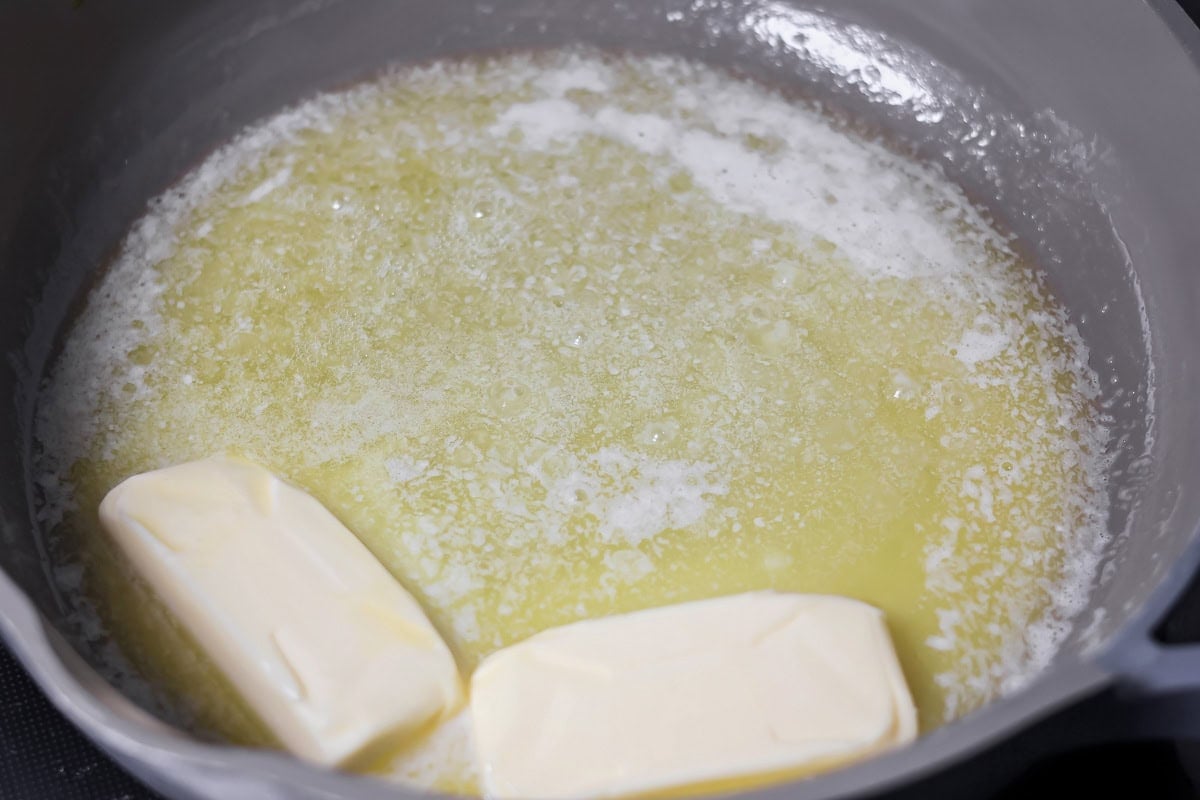 Family favorite brown butter snickerdoodle recipe is easy to make with a soft center, classic tang, and cozy flavor. Butter melting in a pan.