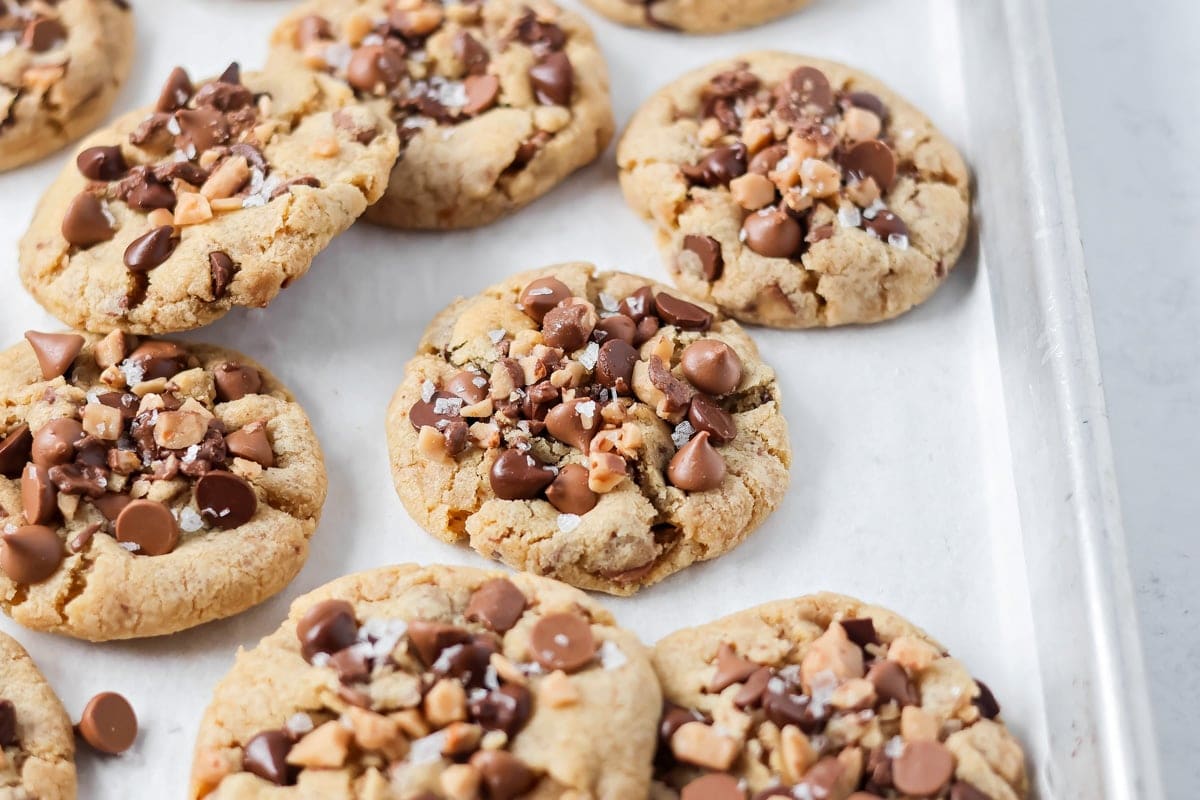 Browned butter toffee chocolate chip cookies with chewy centers and melty chips is an easy bakery-style cookie the whole family loves. Fully baked cookies with extra chocolate chips and sea salt on top.