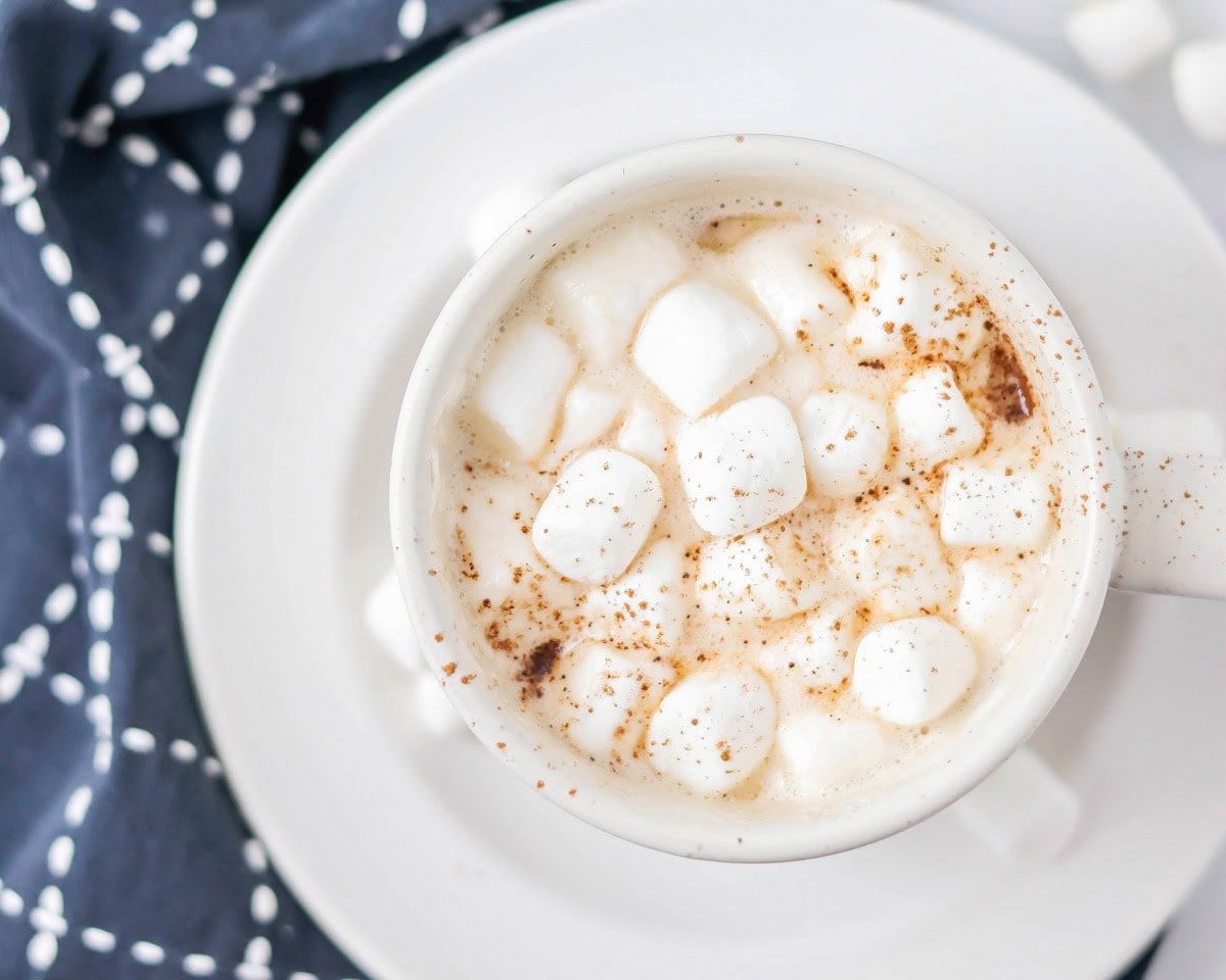 Crockpot hot chocolate recipe in white mug with marshmallows.
