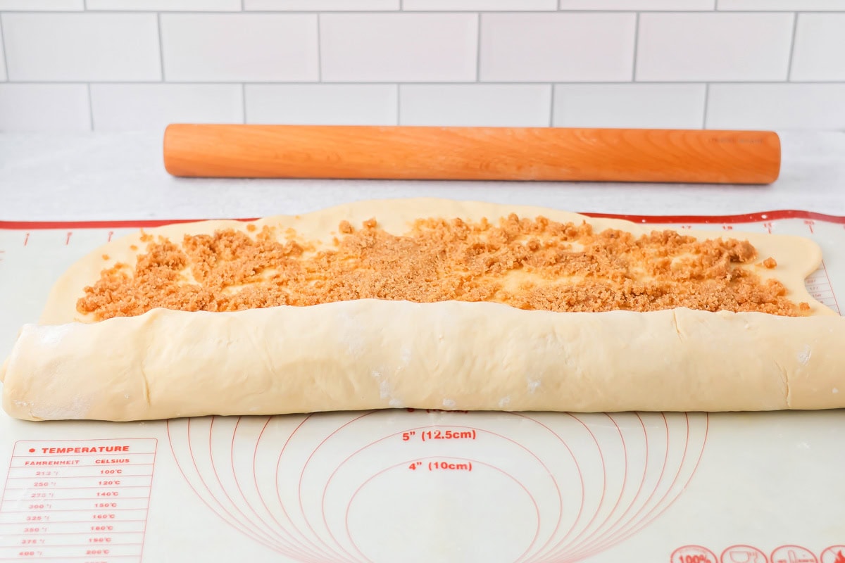 Cinnamon rolls being rolled up.