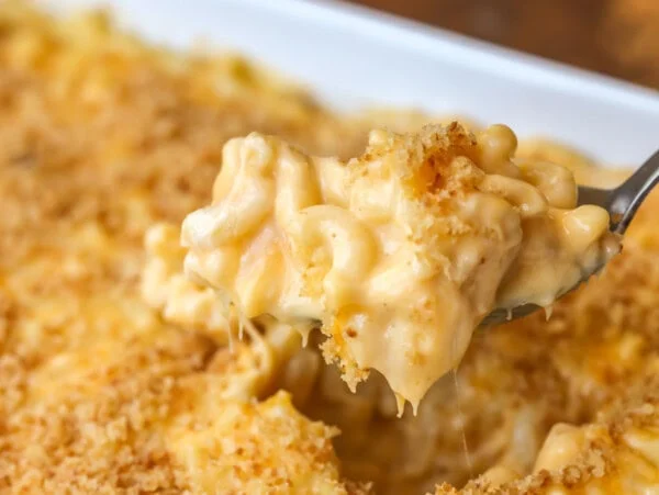 Homemade mac and cheese recipe being scooped out of dish.