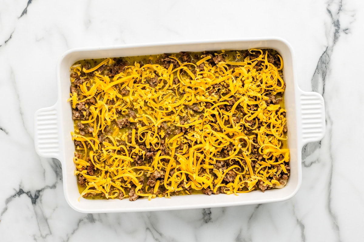 Shredded cheese poured over the sausage breakfast casserole.