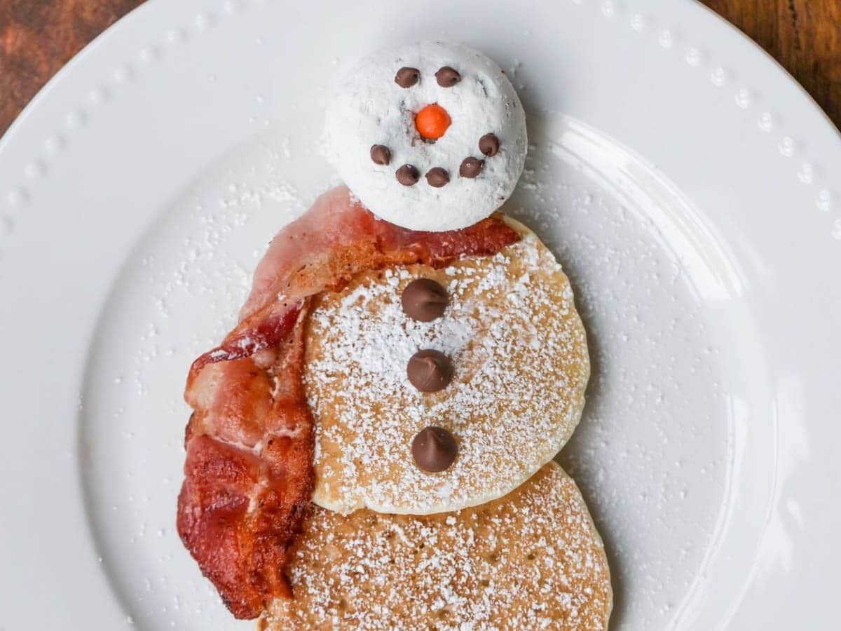 Snowman pancakes on white dish.